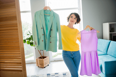 Image attached to message featuring a women holding a jacket in her left hand and a dress in her right.